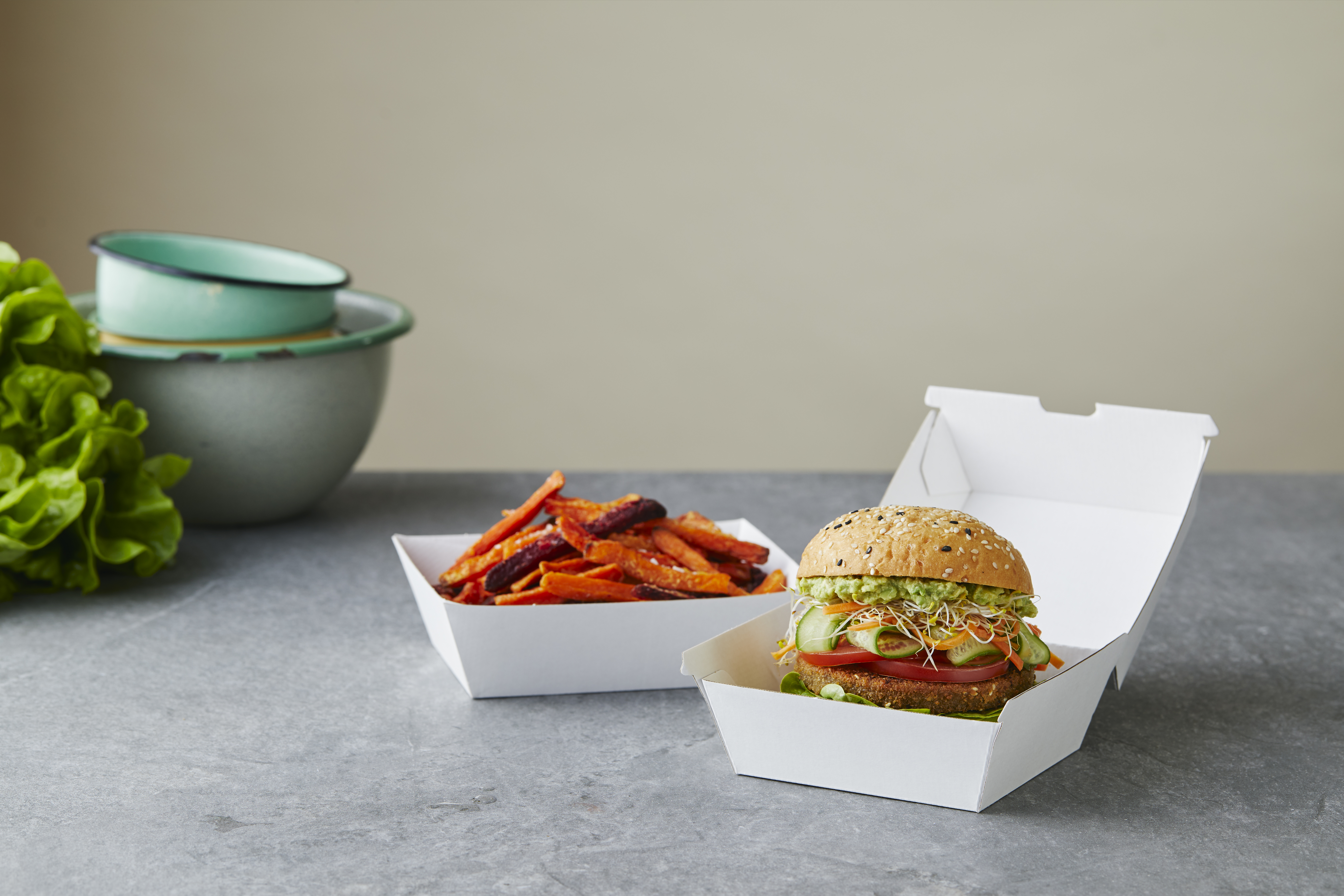 Burger and hot chip served in paper cartons. 