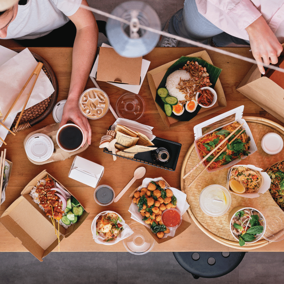 Table full of food packaged in Detpak products. 