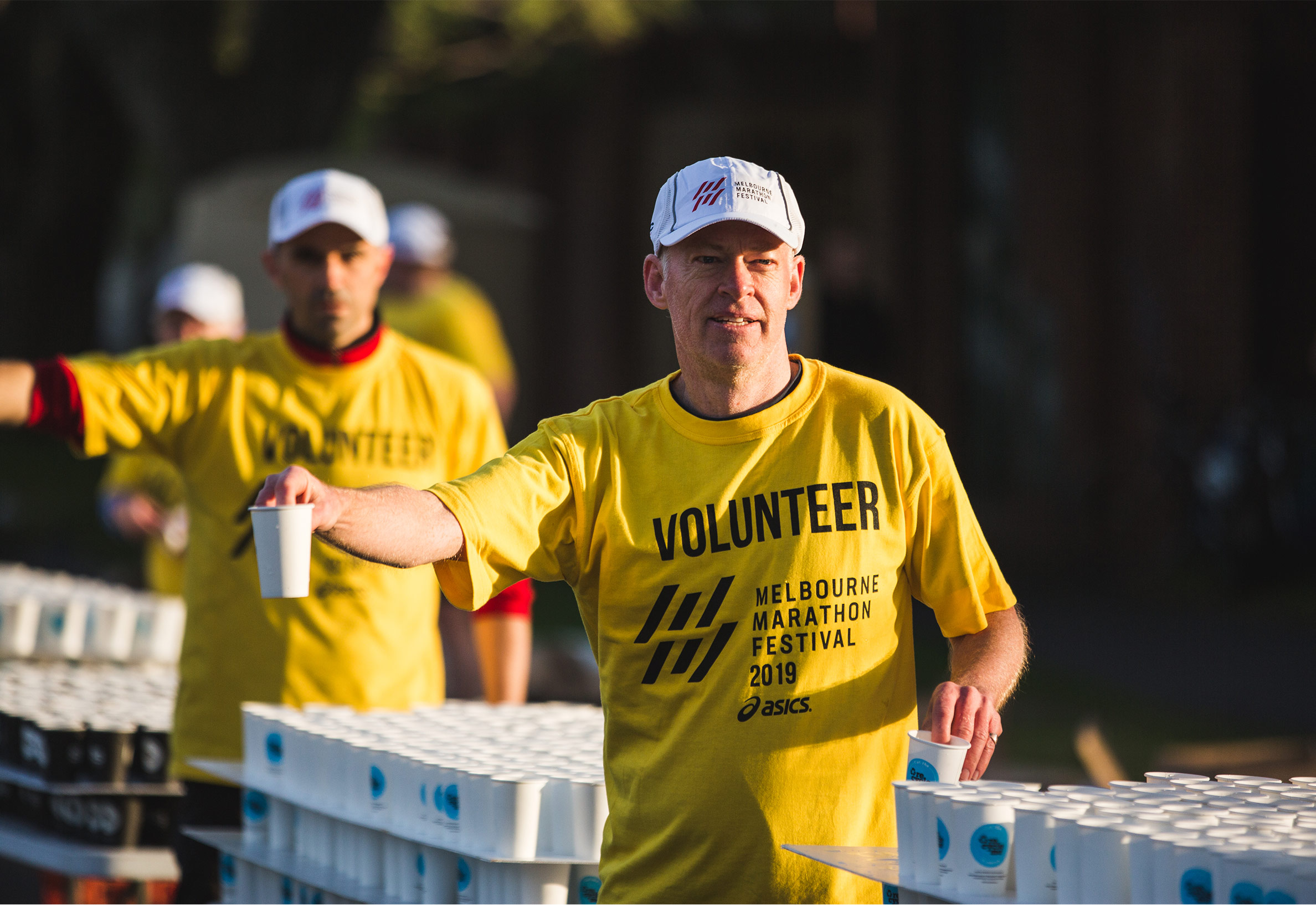 Image of volunteers handing out RecycleMe cups at the Melbourne Marathon