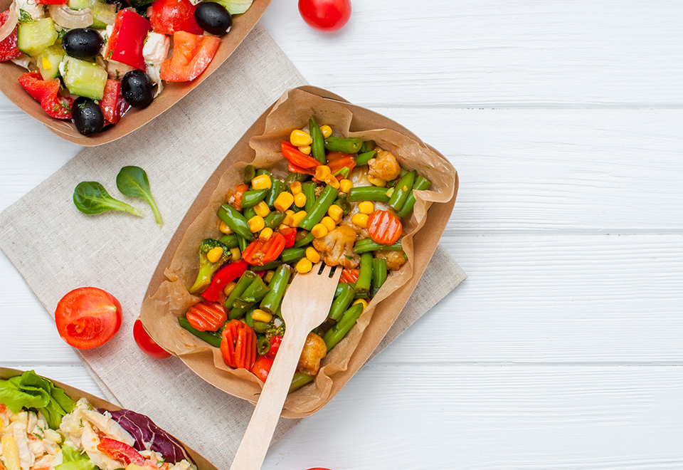 Endura tray filled with salad and pictured with a wooden fork.